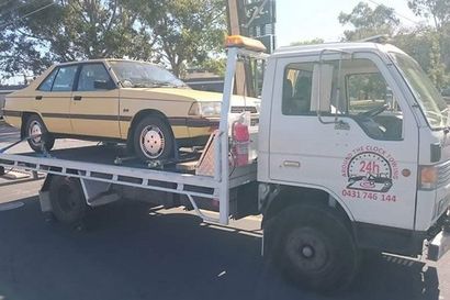 around the clock towing truck towing yellow car