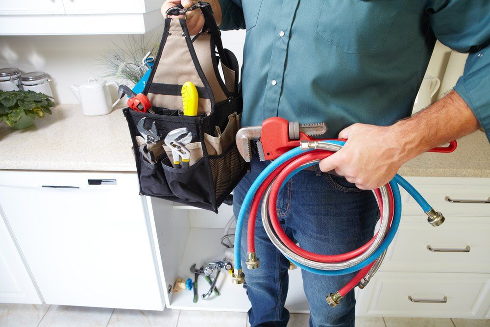 Plumber With Plumbing Tools On The Kitchen — Plumbing Maintenance in Bathurst, NSW