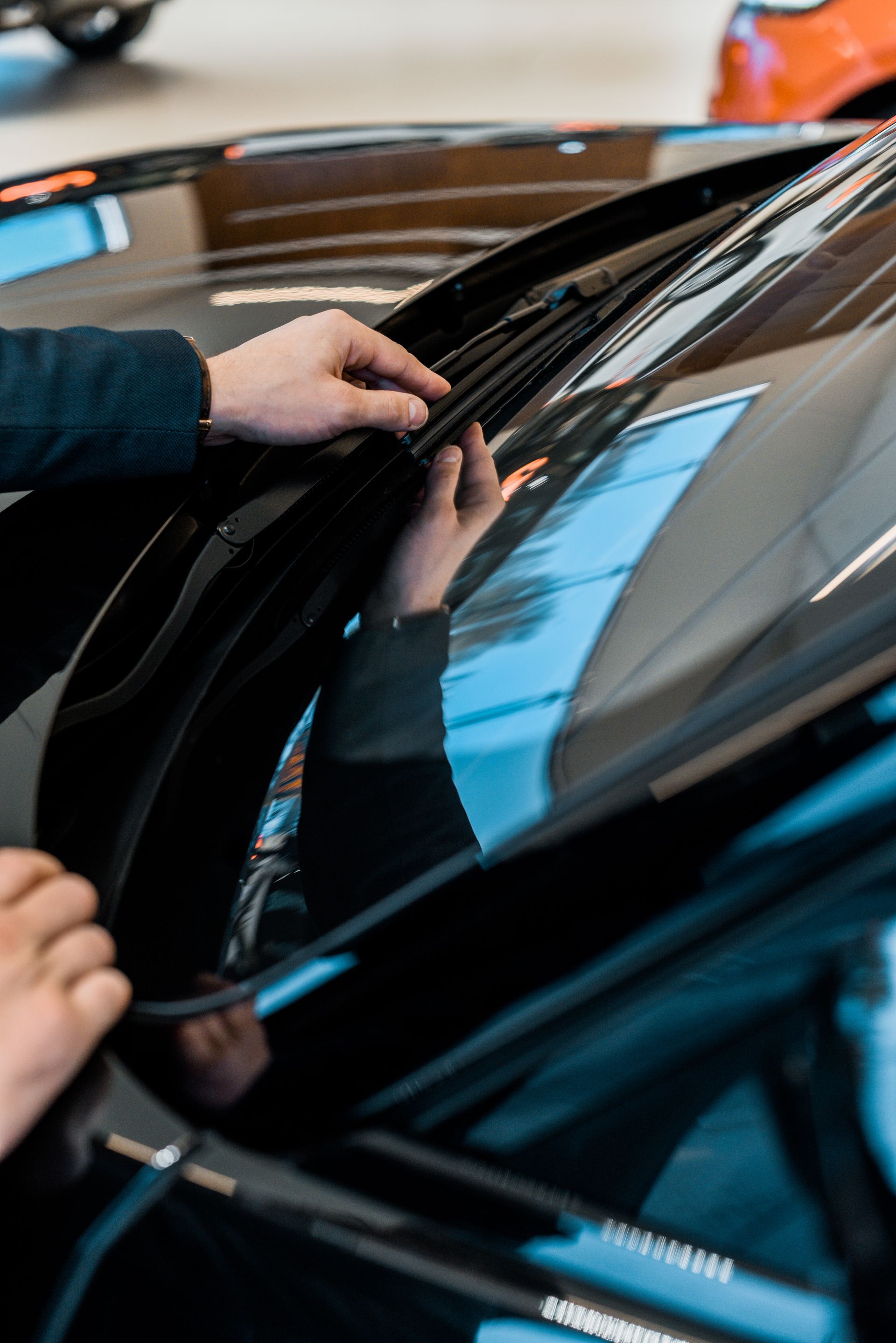 A person is cleaning the windshield of a car.