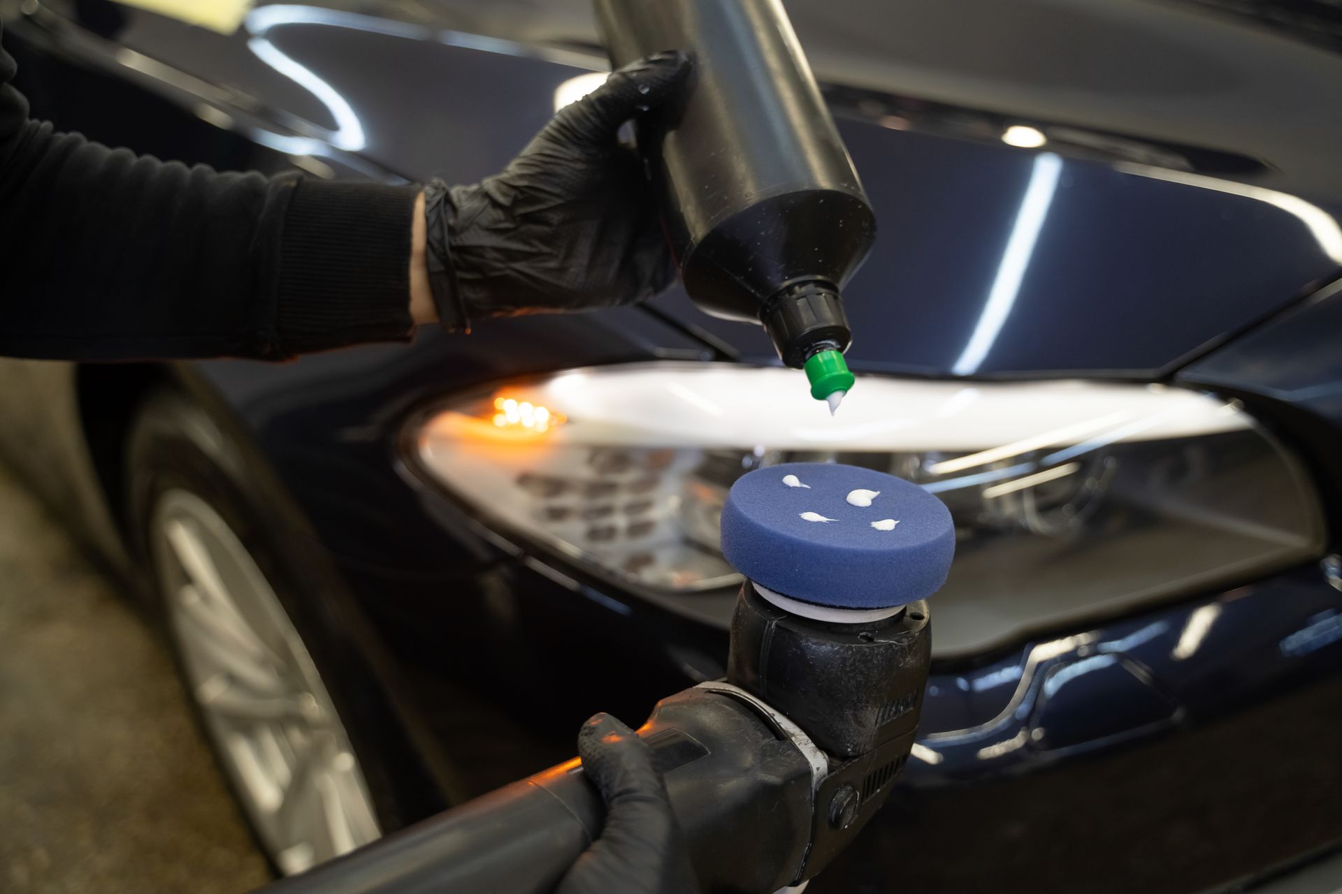 A person is polishing the windshield of a car.