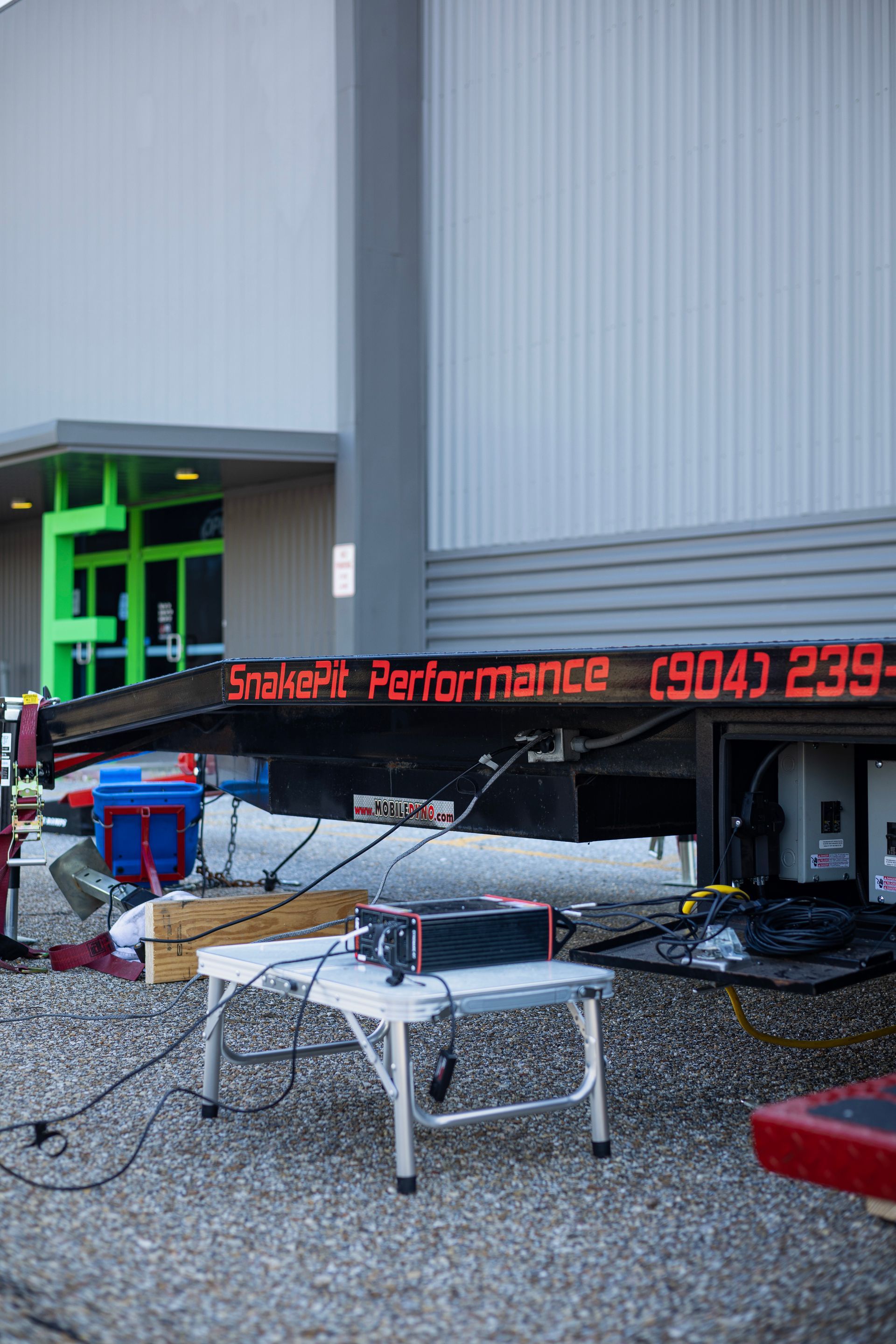 A table with equipment in front of a trailer displaying 