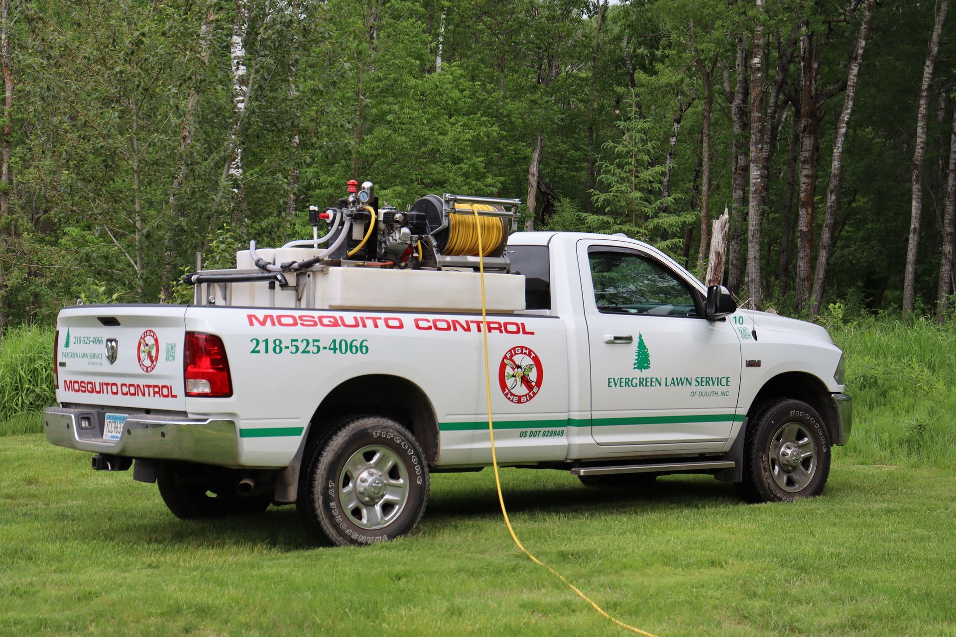 A man is using a machine to spray smoke on the grass.