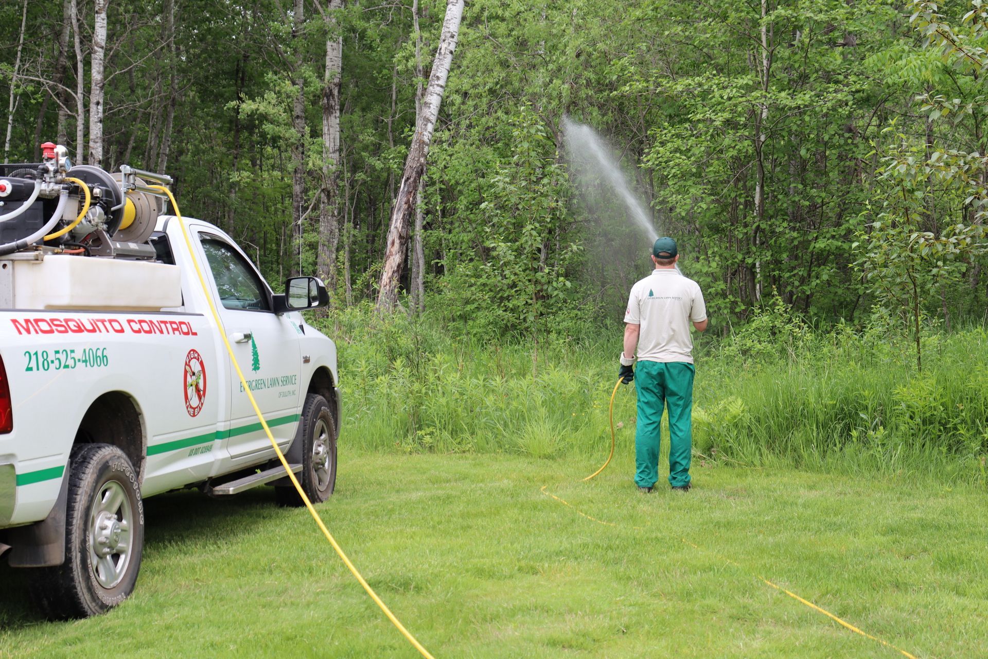 Pest exterminator providing mosquito control treatment at a residential property in Cloquet, MN.