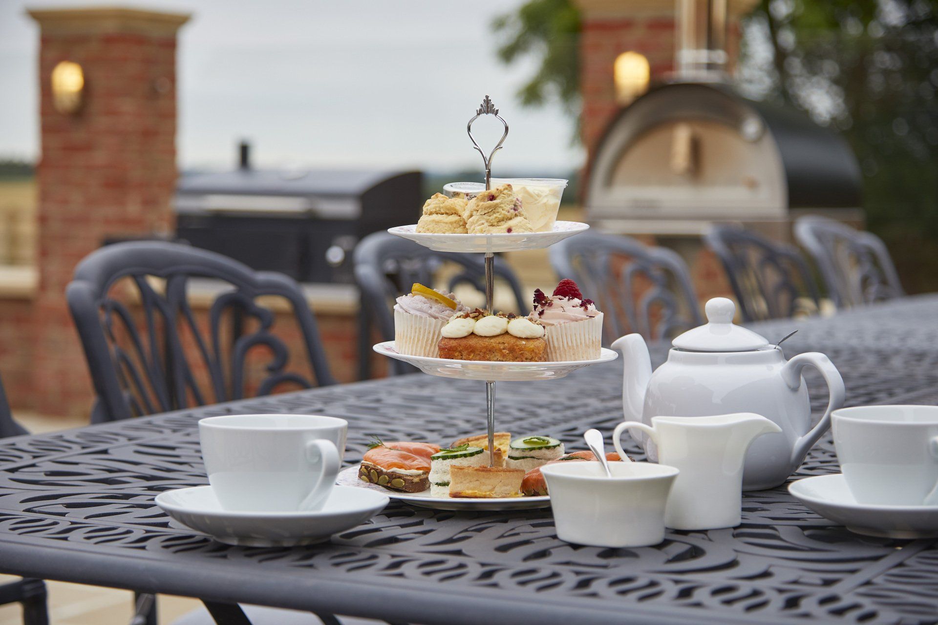 A table topped with plates of food and cups of tea.