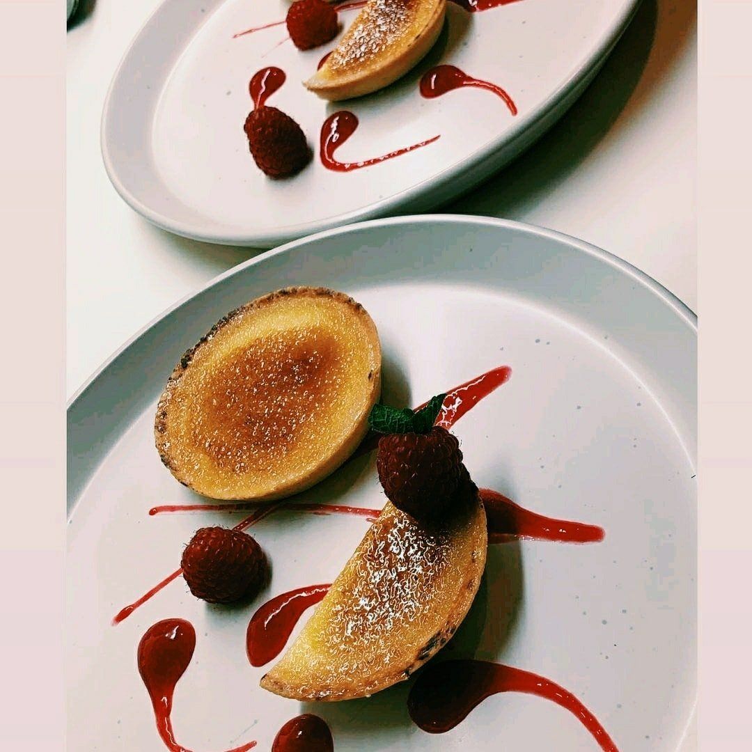 Two plates of food with strawberries and syrup on them