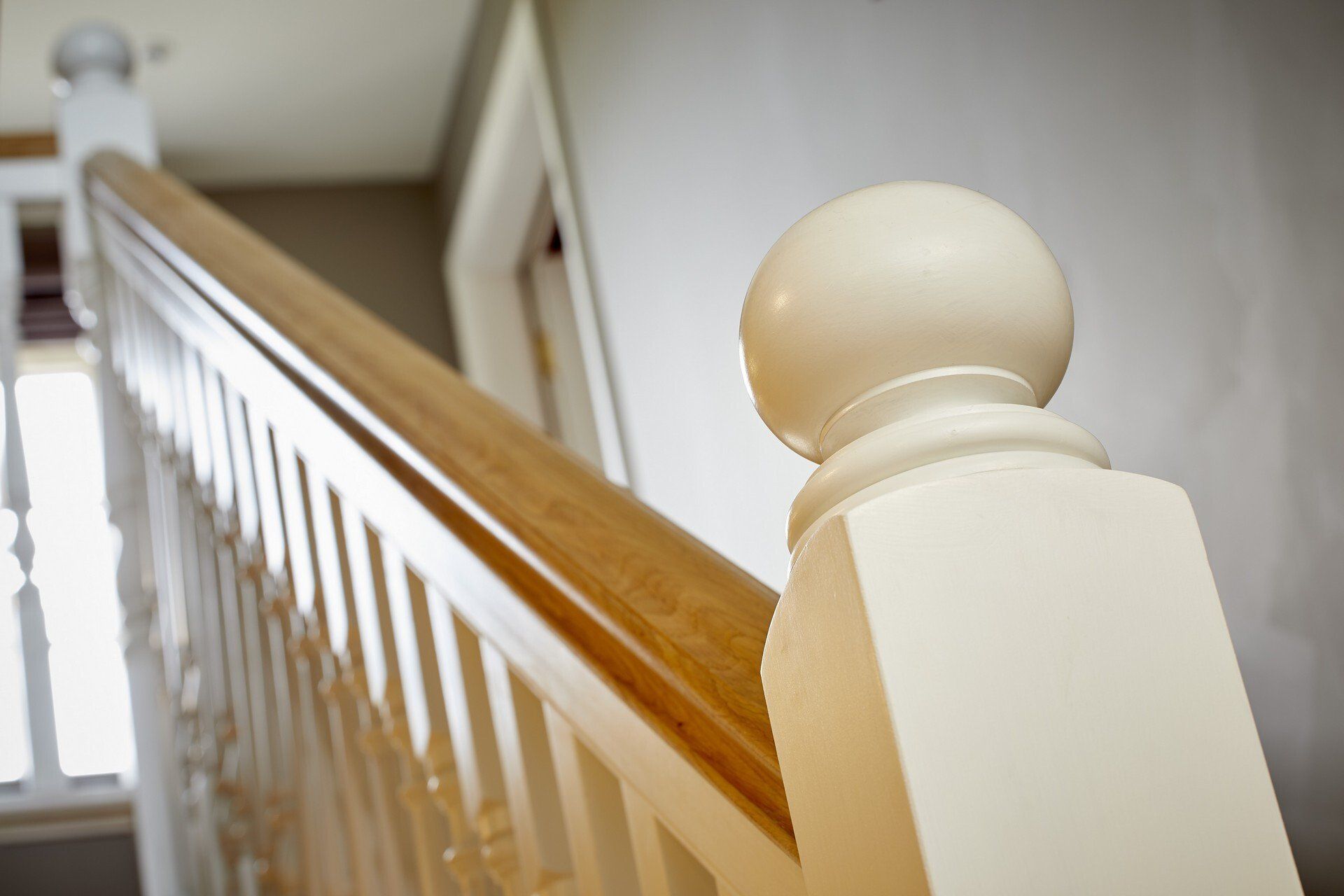 A close up of a white railing with a wooden handrail