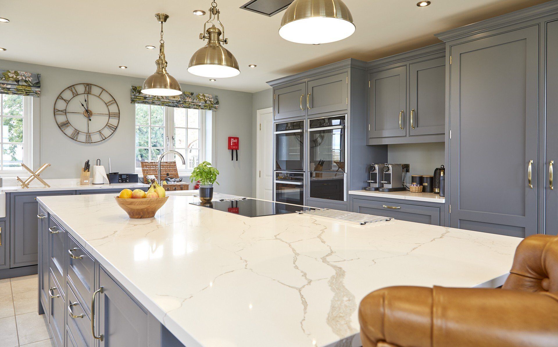 A kitchen with a large island and a clock on the wall.