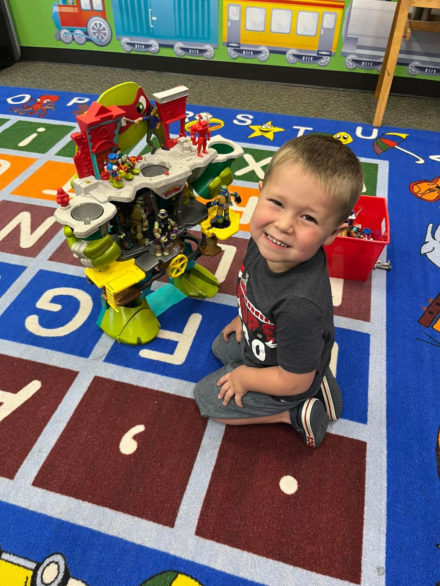 A young boy is sitting on the floor playing with a toy.