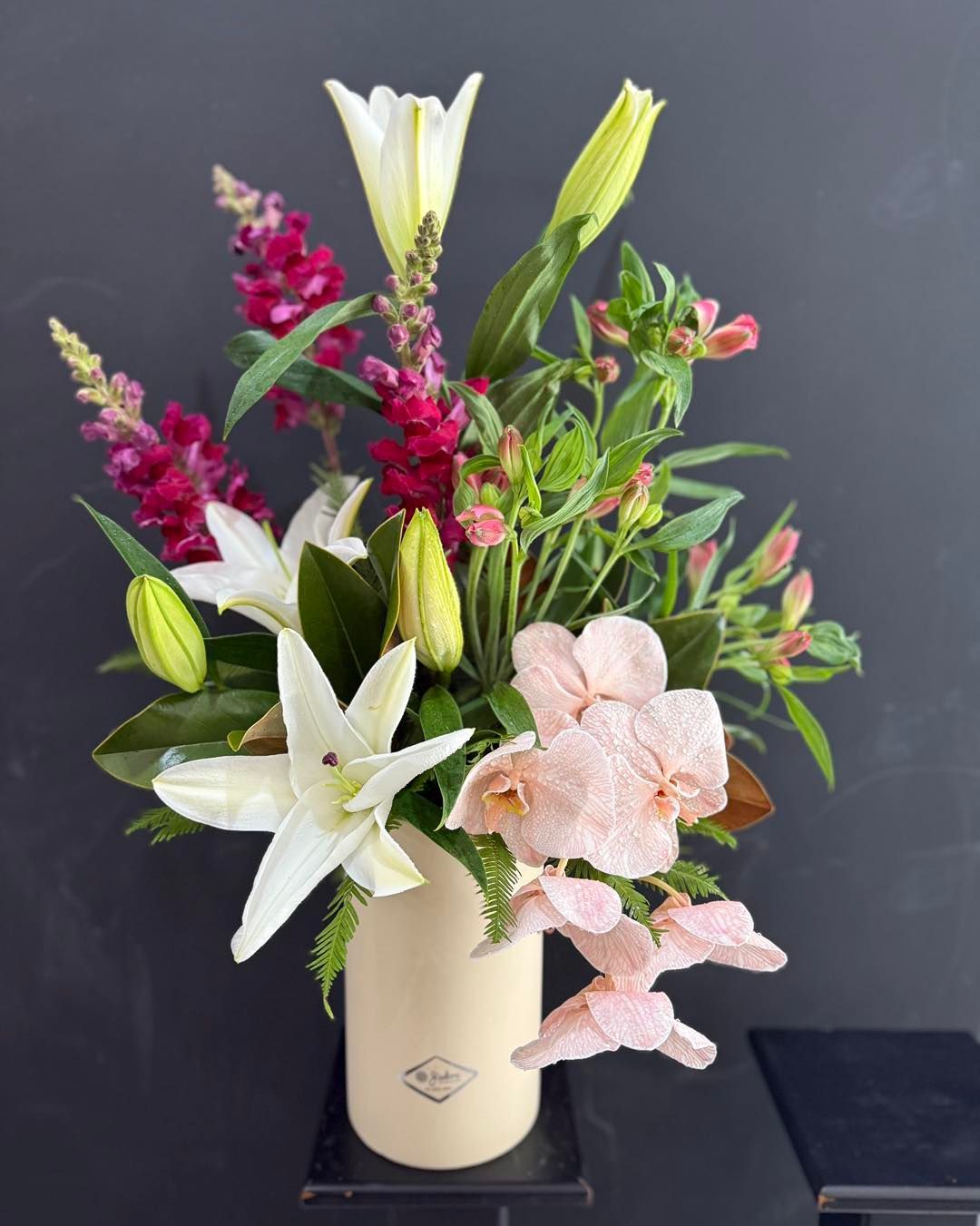 White roses and small white flowers arranged in a floral bouquet, tied with pink ribbon — J'adore Flowers & Gifts Cairns in Earlville, QLD