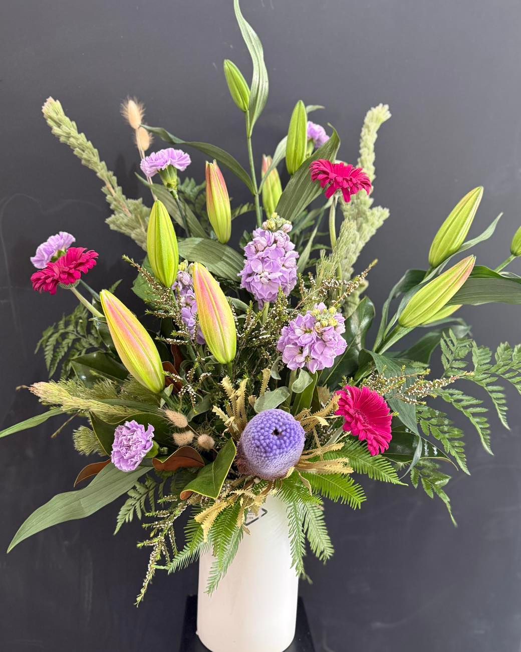 Bouquet of yellow, orange, and white flowers in brown paper with a white ribbon -J'adore Flowers & Gifts Cairns in Earlville, QLD