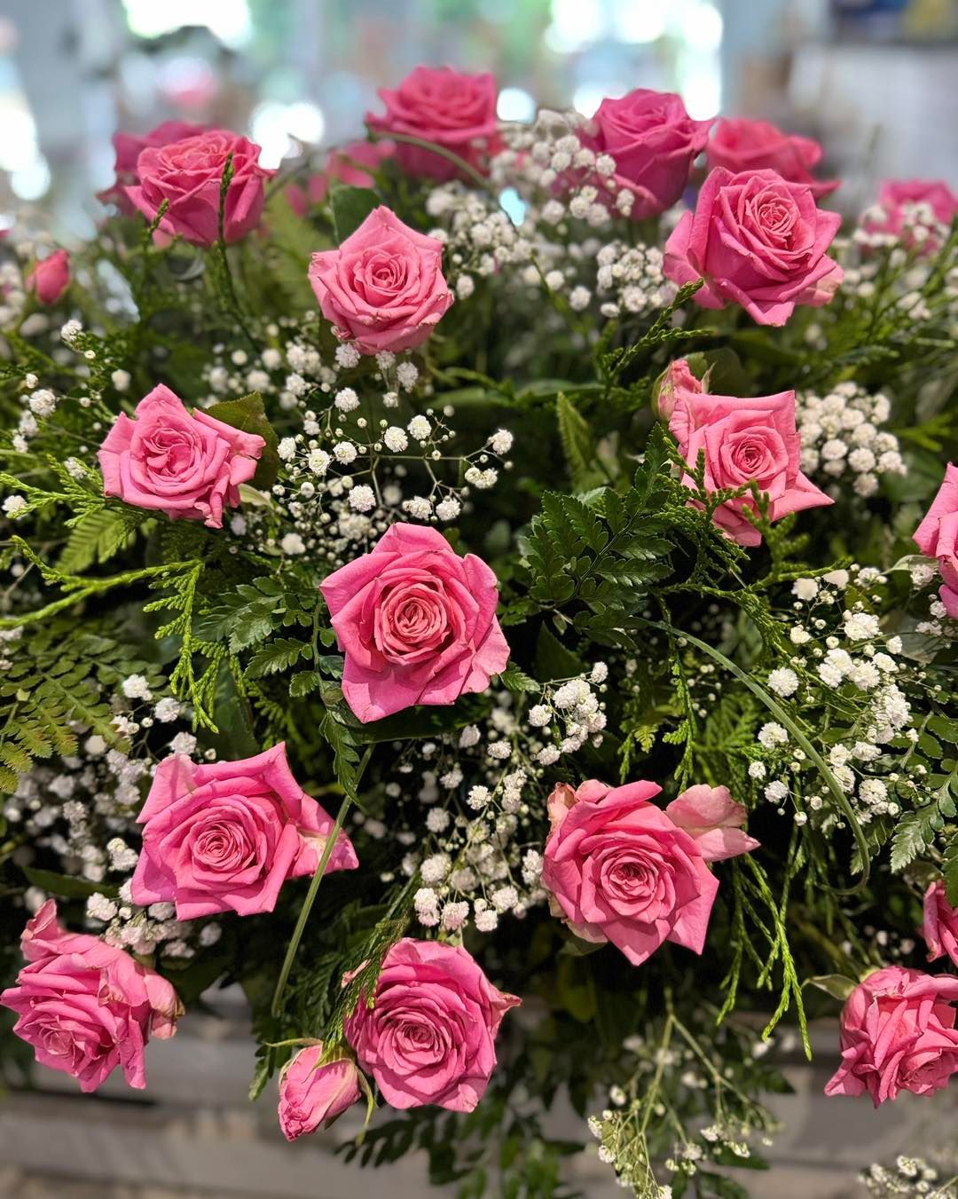 Arrangement of pink roses and white baby's breath flowers surrounded by green foliage — J'adore Flowers & Gifts Cairns in Earlville, QLD
