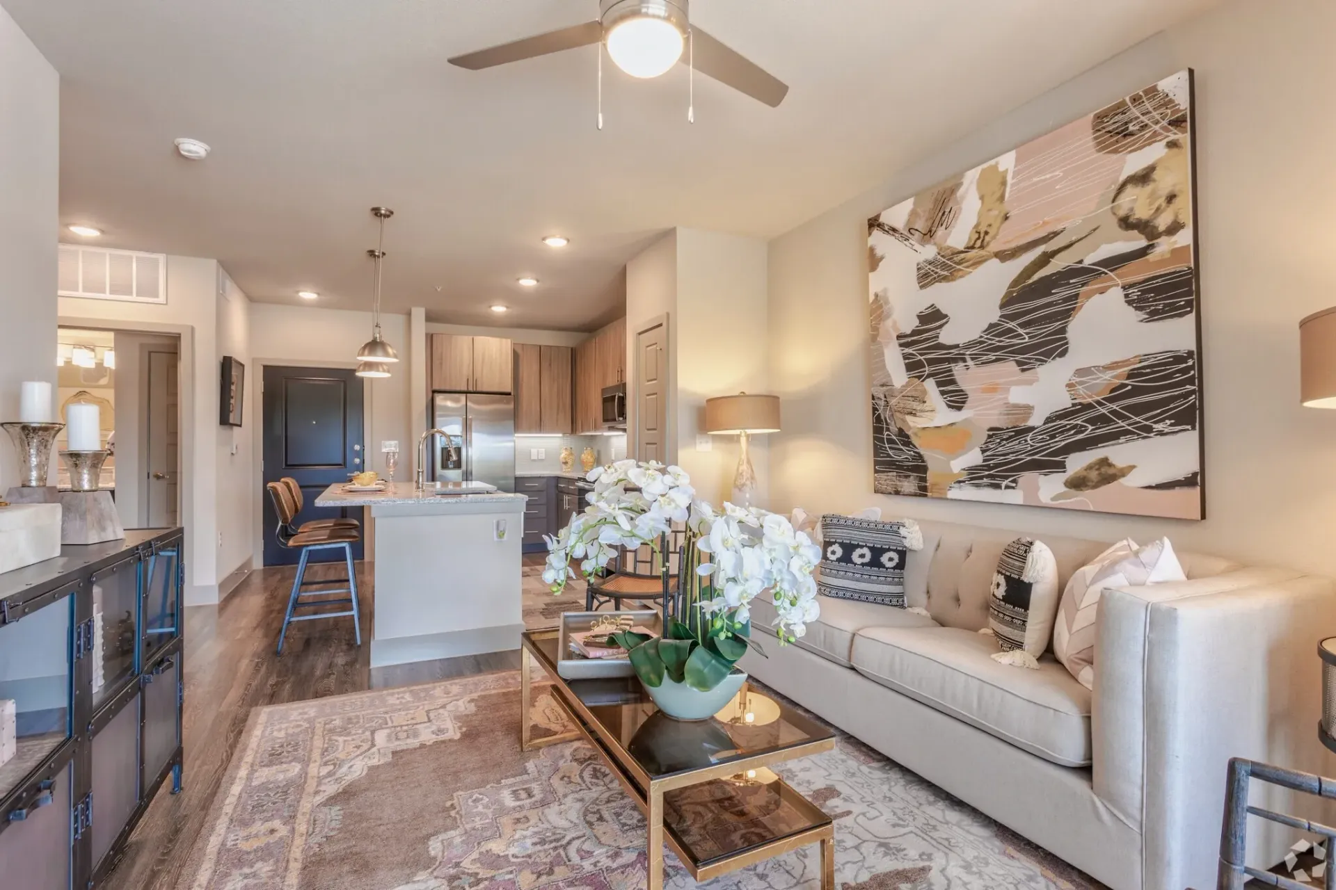 Open-concept living area with kitchen island, sofa, and abstract wall art.