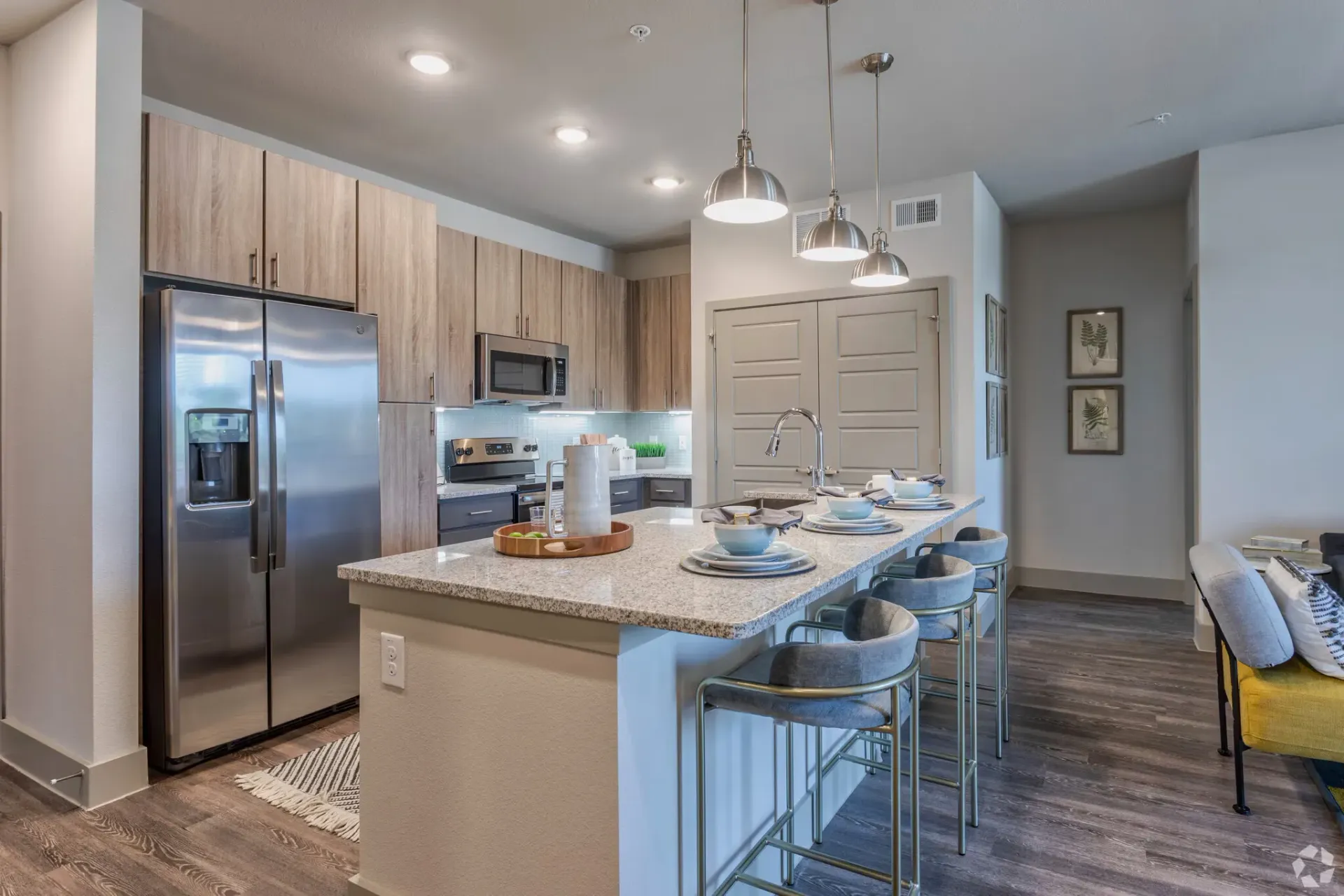 Modern kitchen with island, stainless steel appliances, and bar seating.