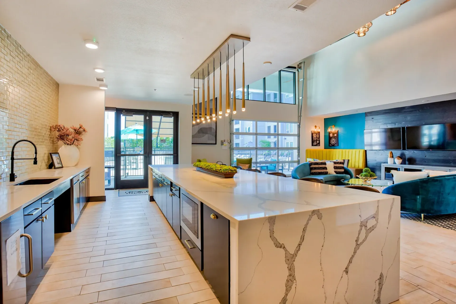 Open-concept community kitchen and lounge with a large marble island and seating.