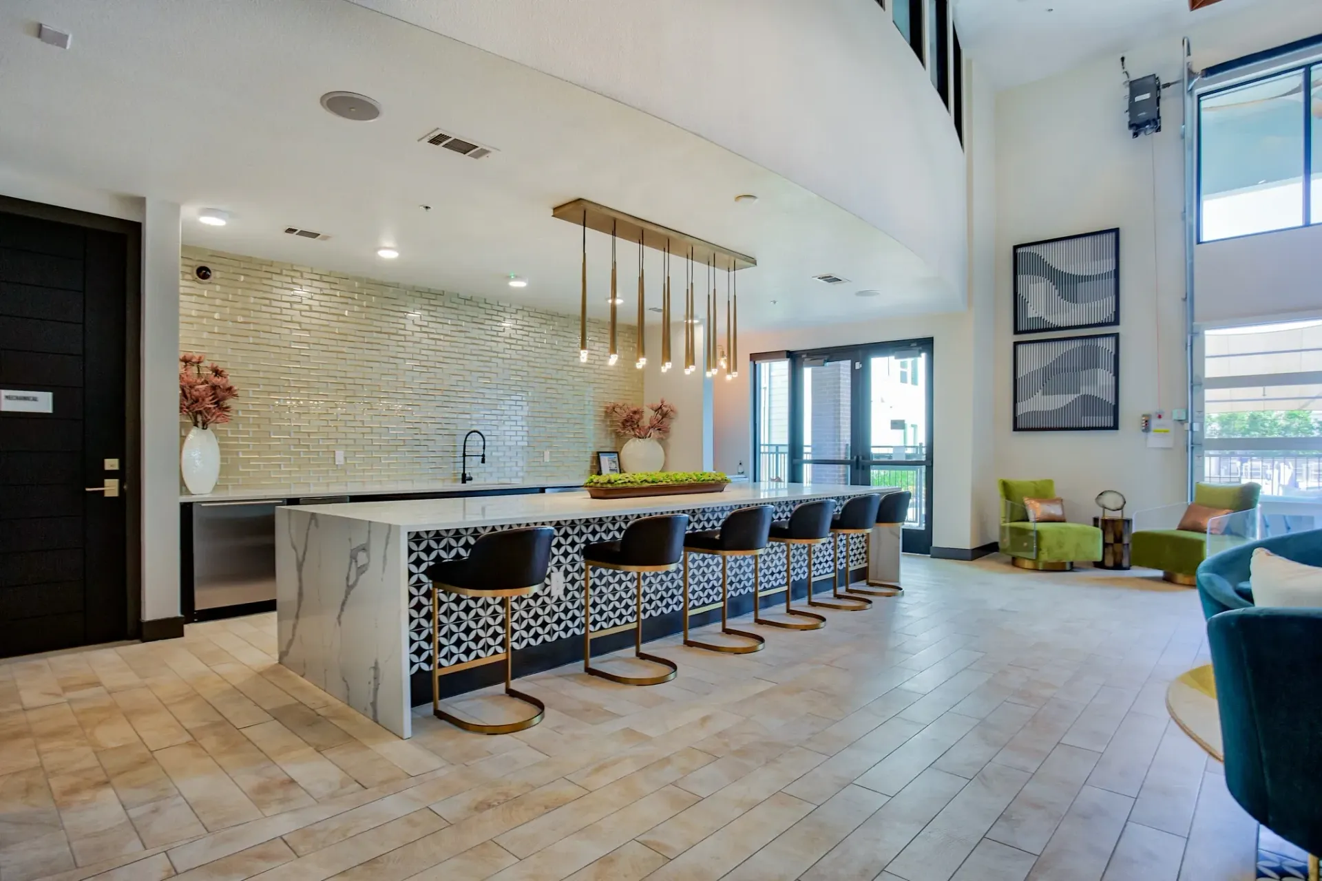 Modern community lounge with marble bar, pendant lights, and seating area.