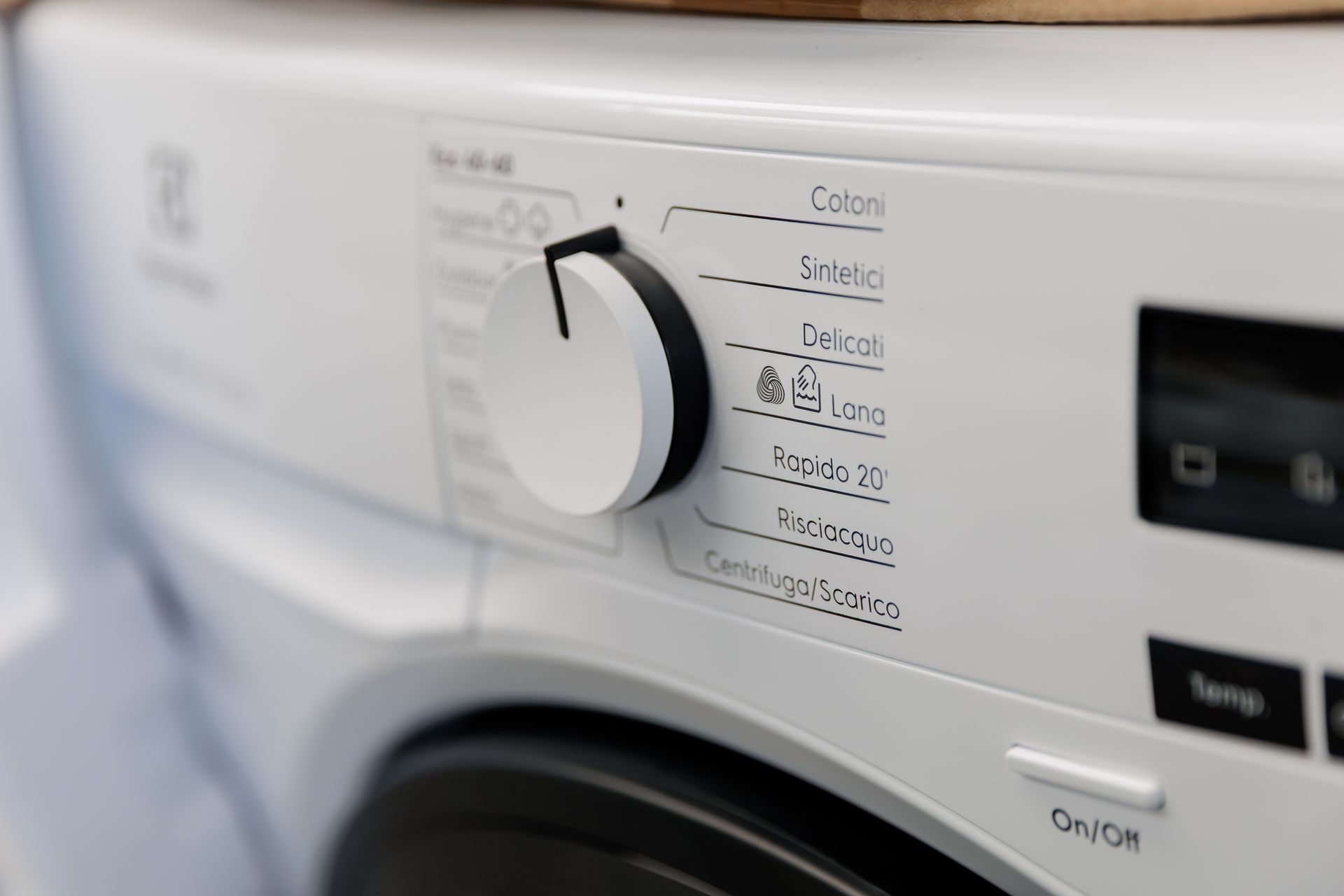 Uno showroom a cielo aperto, in stile magazzino, che espone file di lavatrici e altri elettrodomestici su un pavimento di cemento.