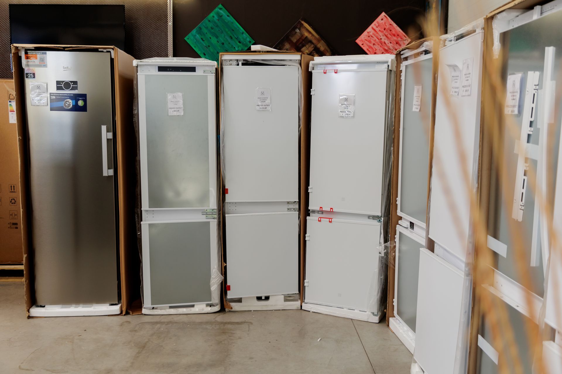 Una reception professionale con scrivania in legno scuro, pavimento in piastrelle grigie lucide e pareti color bordeaux sotto un soffitto metallico.