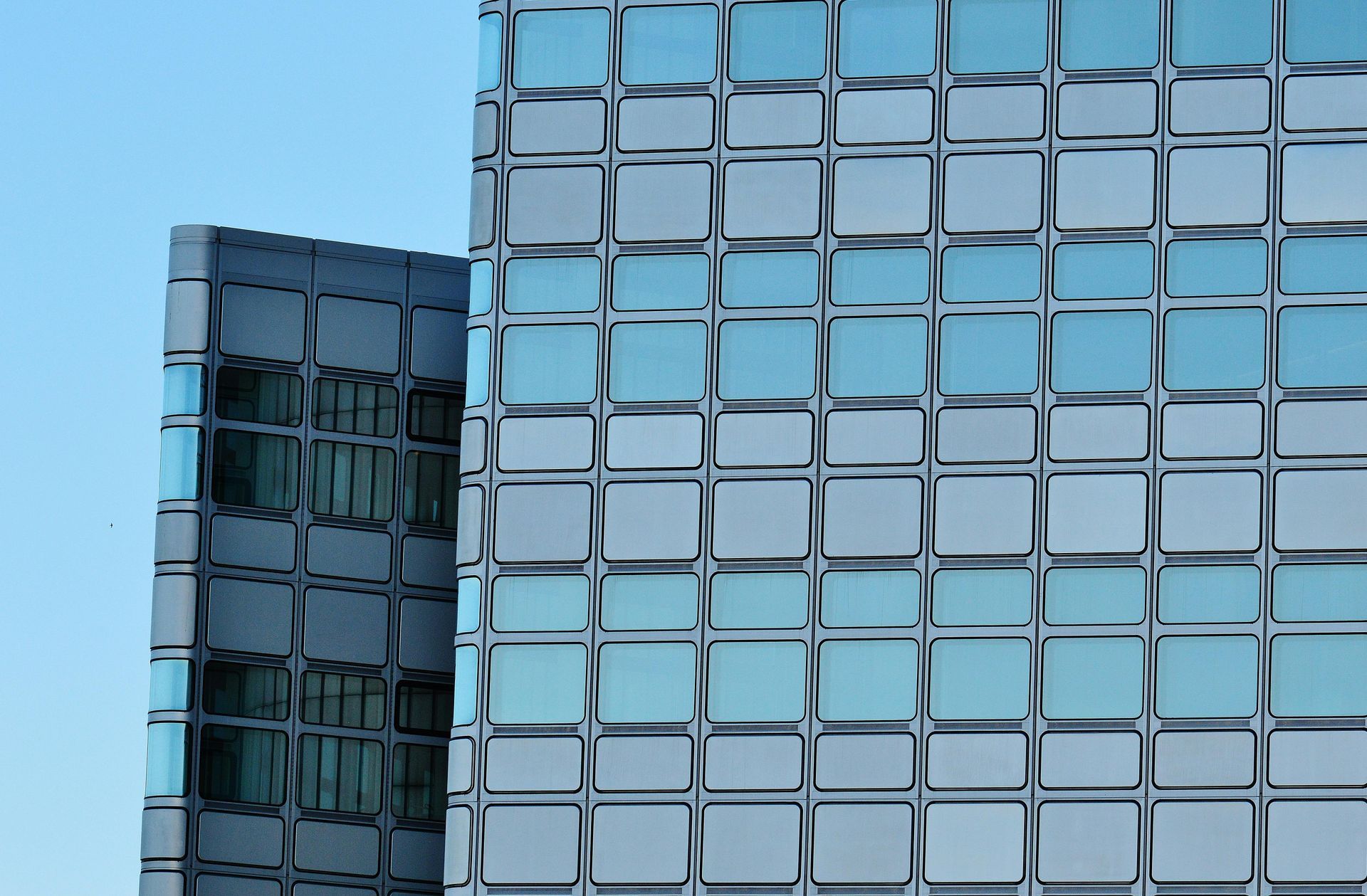 Woman in straw hat smiles, holding wine glass near a lake.