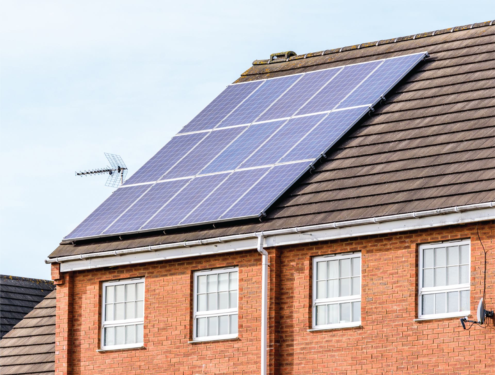 A brick house with solar panels on the roof.