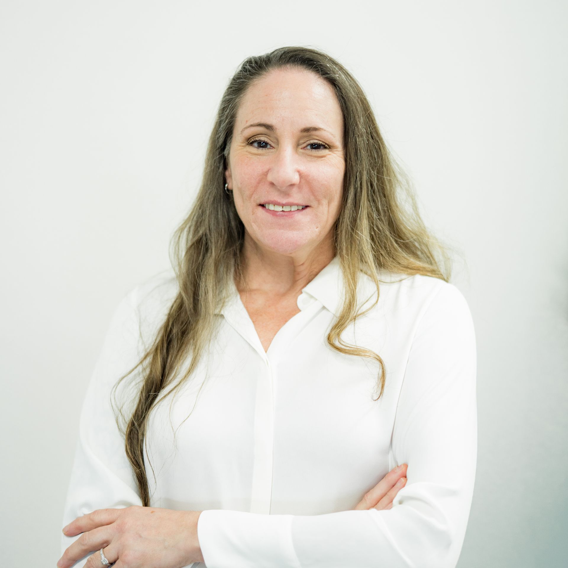 A female surgeon wearing a mask is standing in front of a table with surgical equipment.