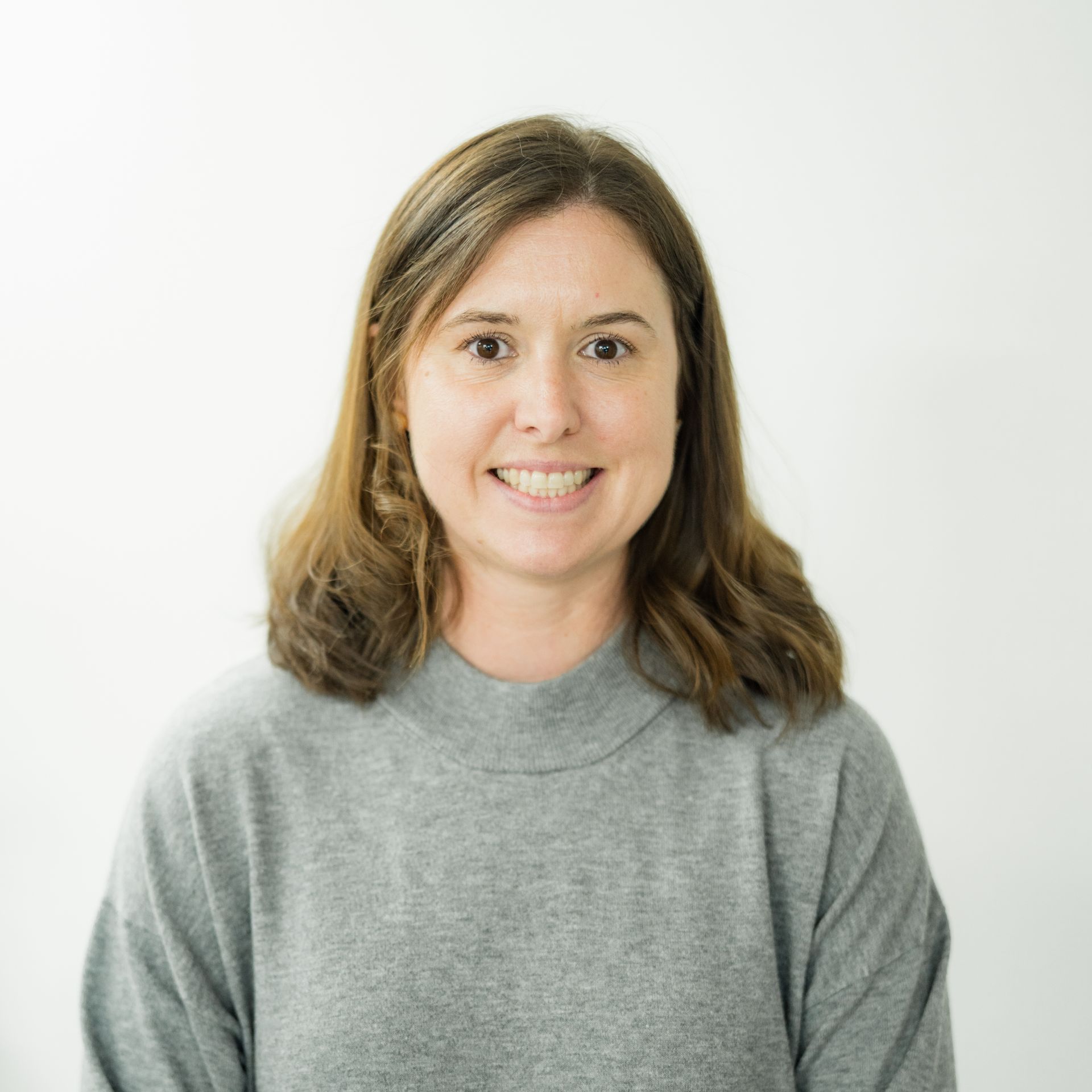 A female surgeon wearing a mask is standing in front of a table with surgical equipment.