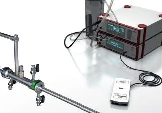 A remote control is sitting next to a machine on a table.