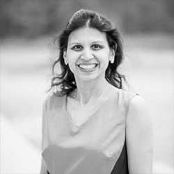 A woman is smiling in a black and white photo.