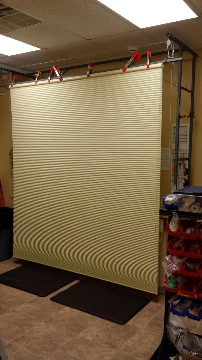 A large yellow blind is hanging from the ceiling in a room.