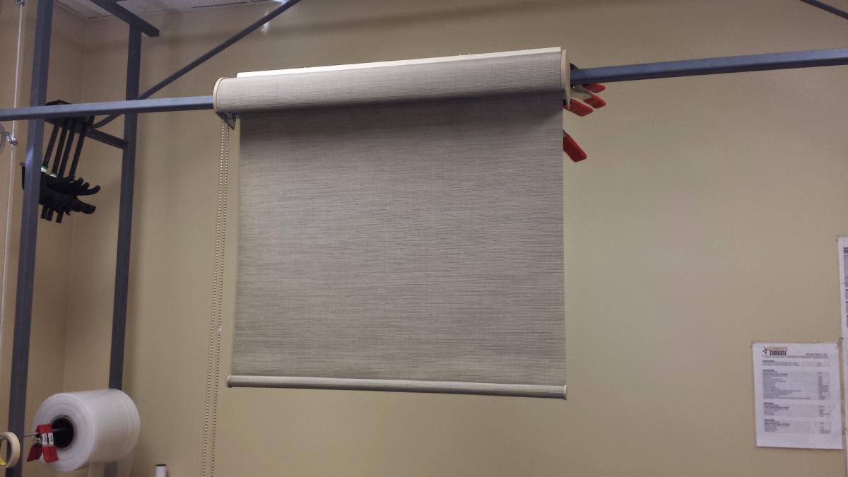 A roll of carpet is hanging on a rack in a room.