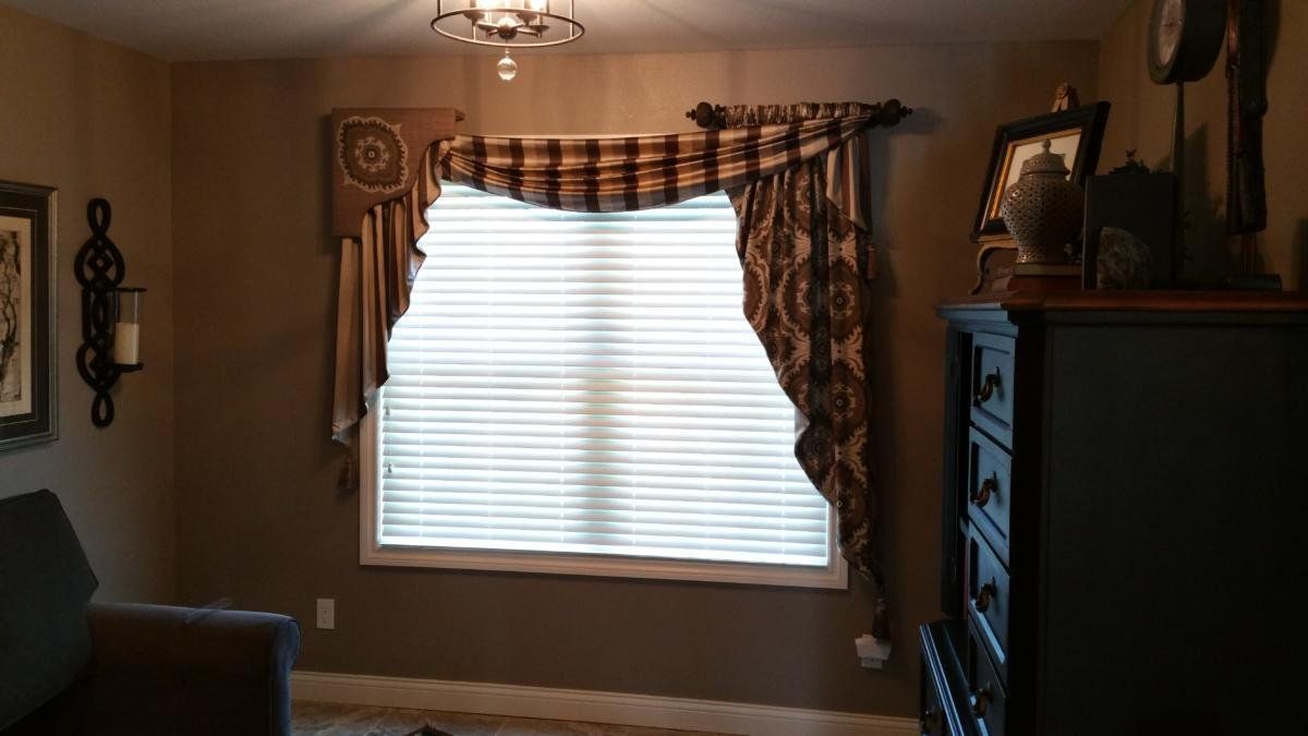 A living room with a couch , dresser , and window.