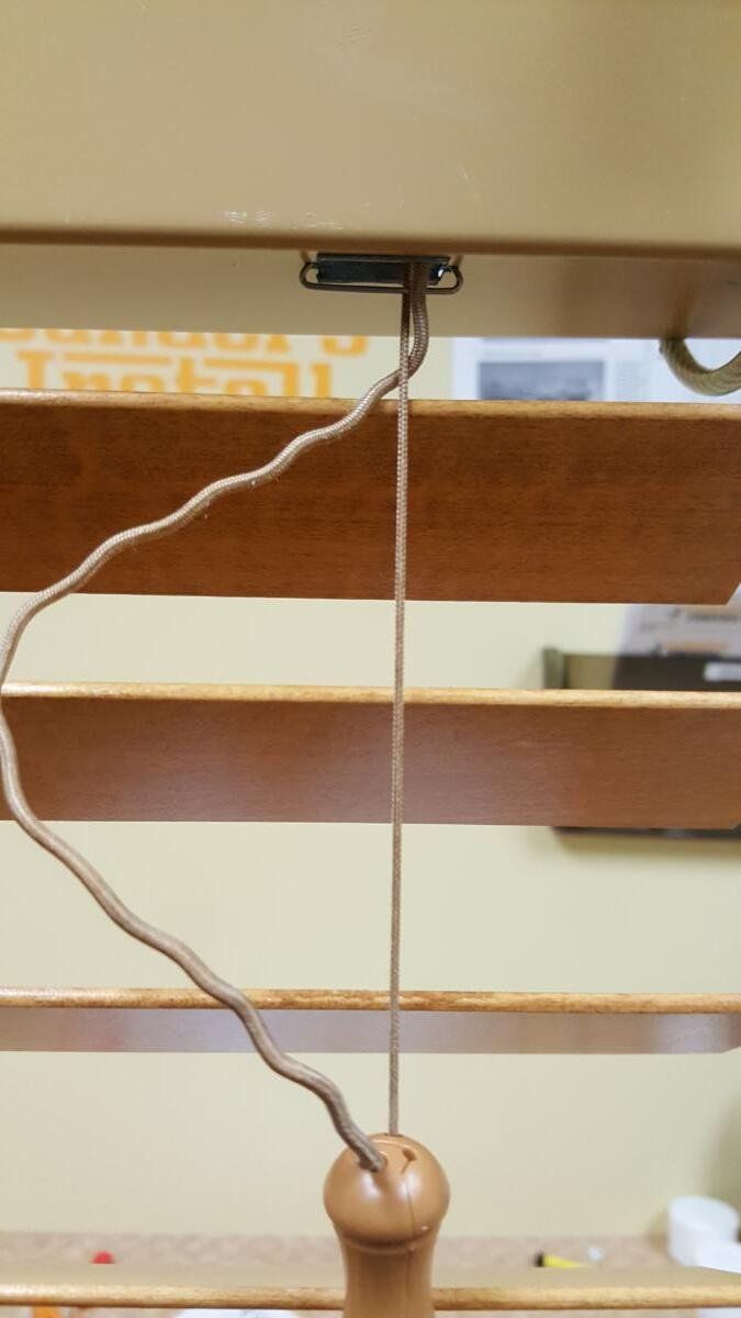 A wooden blind with a string attached to it