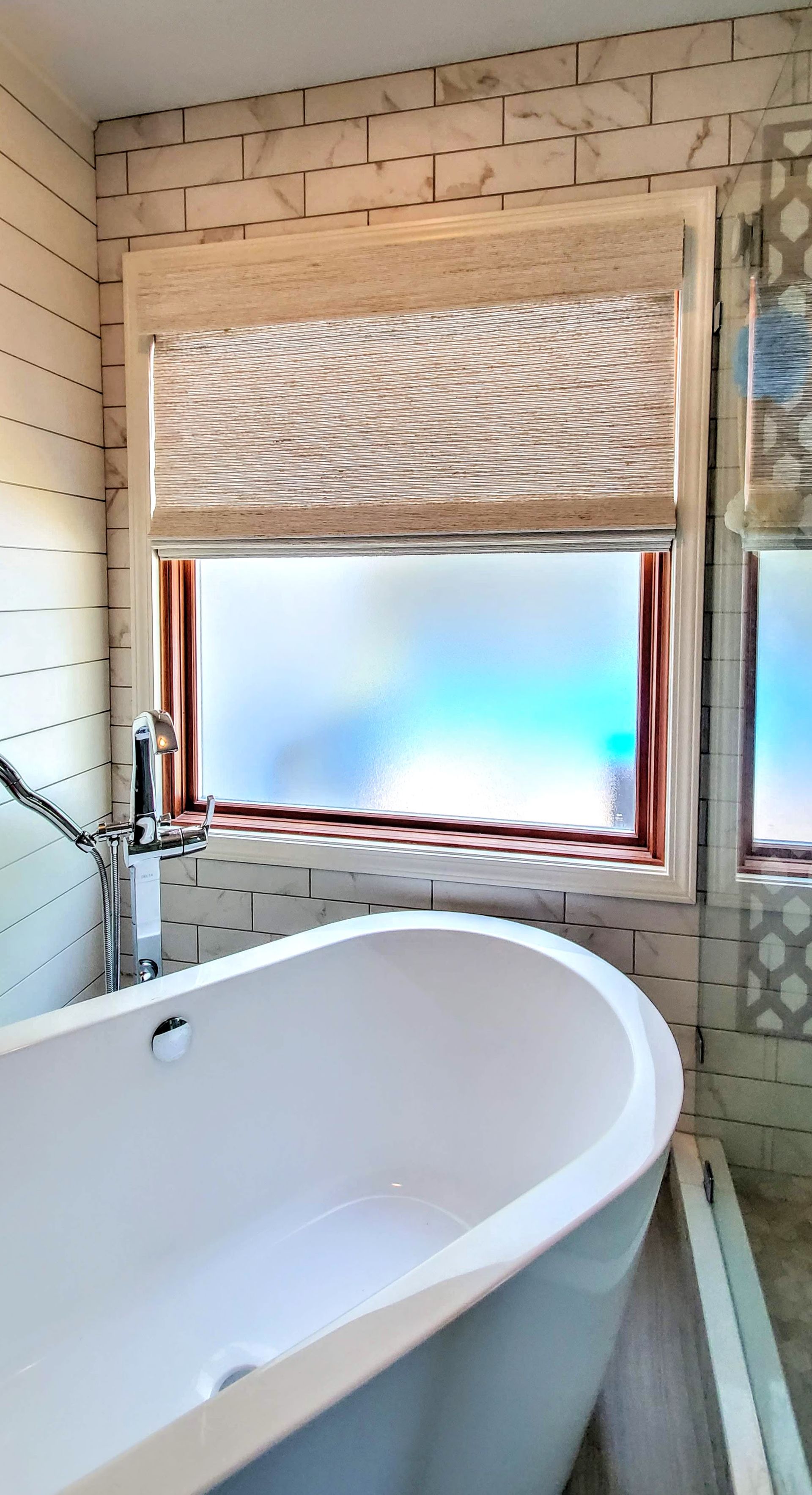 A bathroom with a bathtub and a window.