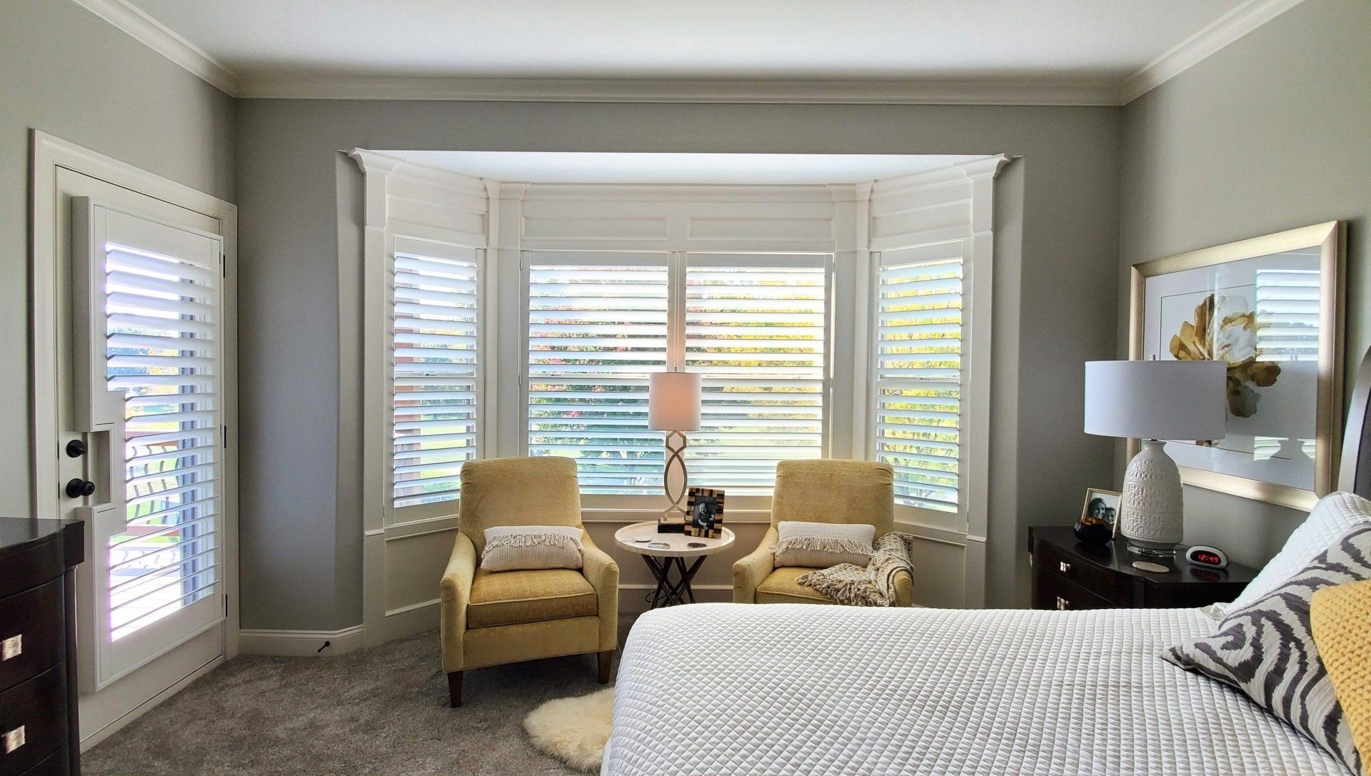 A bedroom with a bed , two chairs , a table and a window.