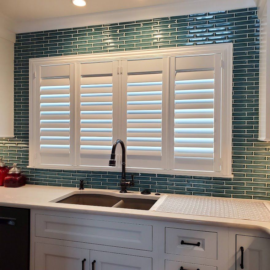 A kitchen with a sink and shutters on the window