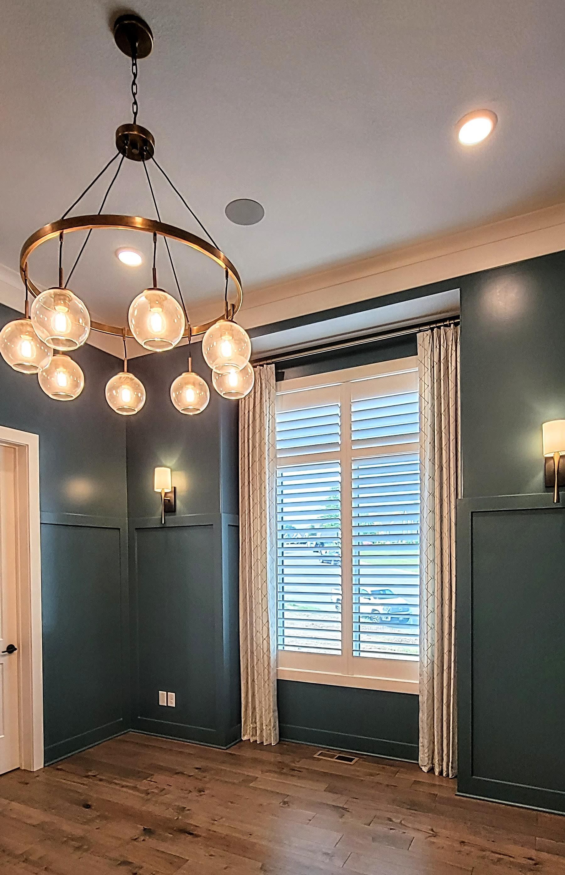 A room with a chandelier hanging from the ceiling and a window.