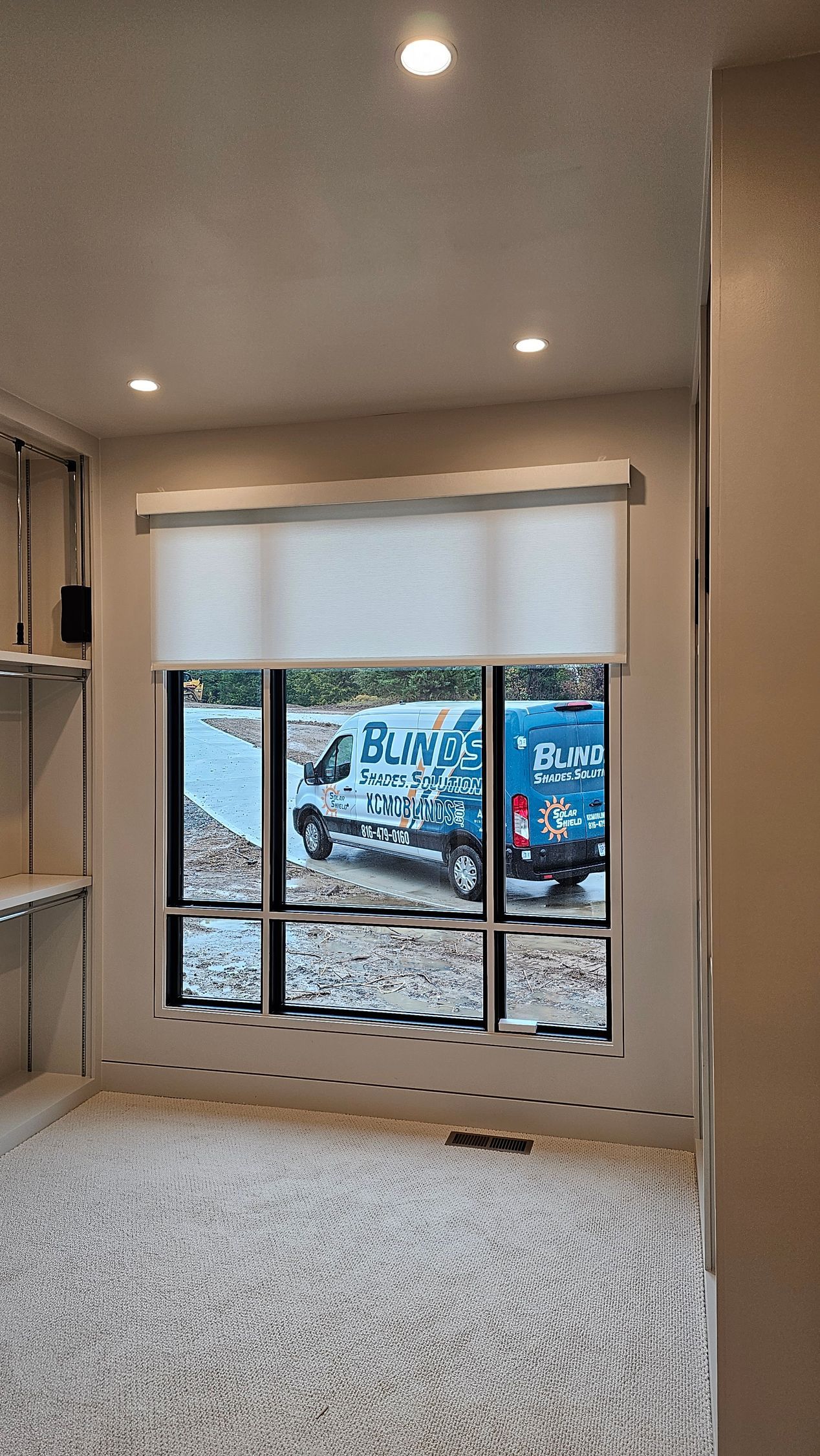A room with a lot of windows and a blue truck in the background.