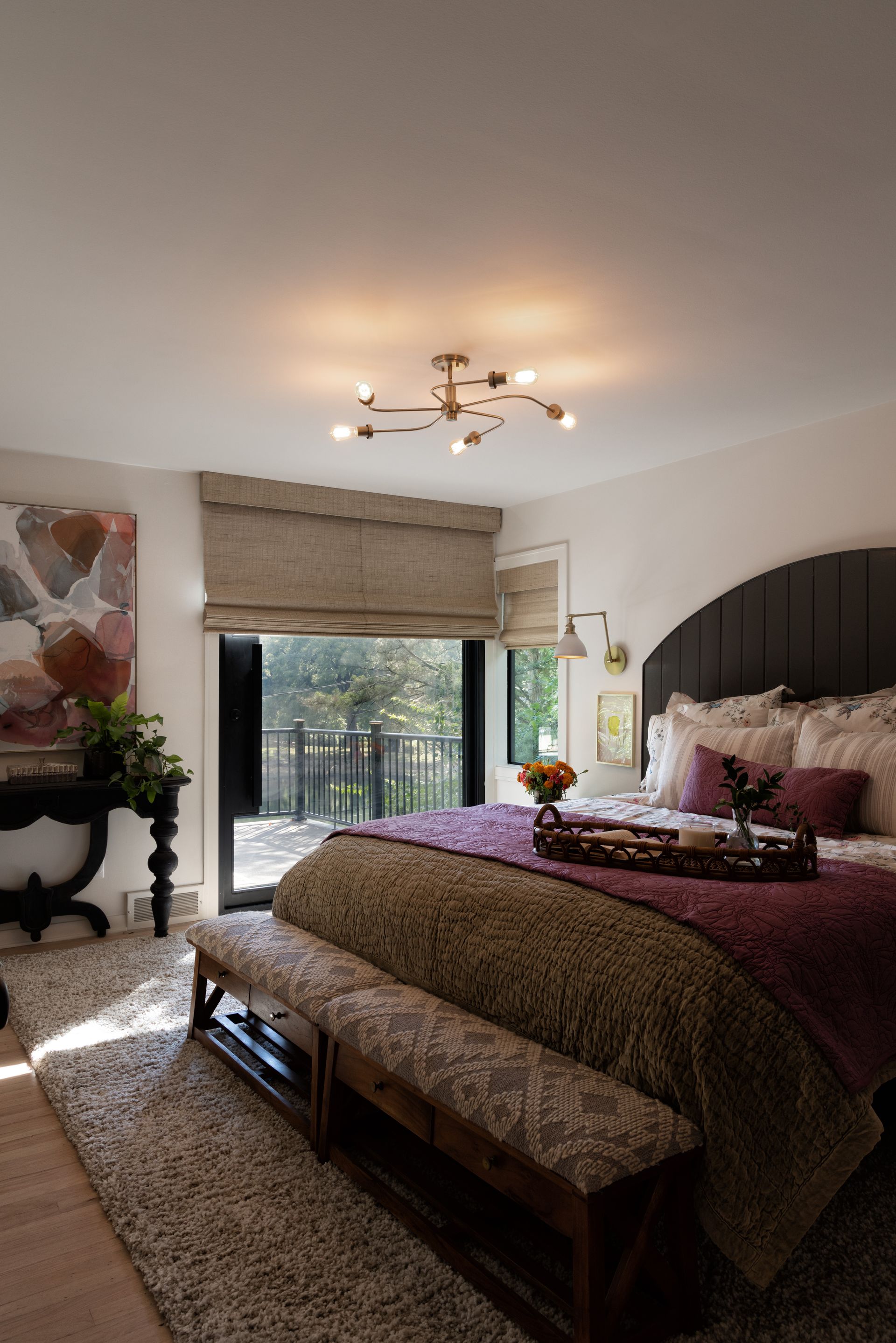 A bedroom with a large bed and a bench in front of it.