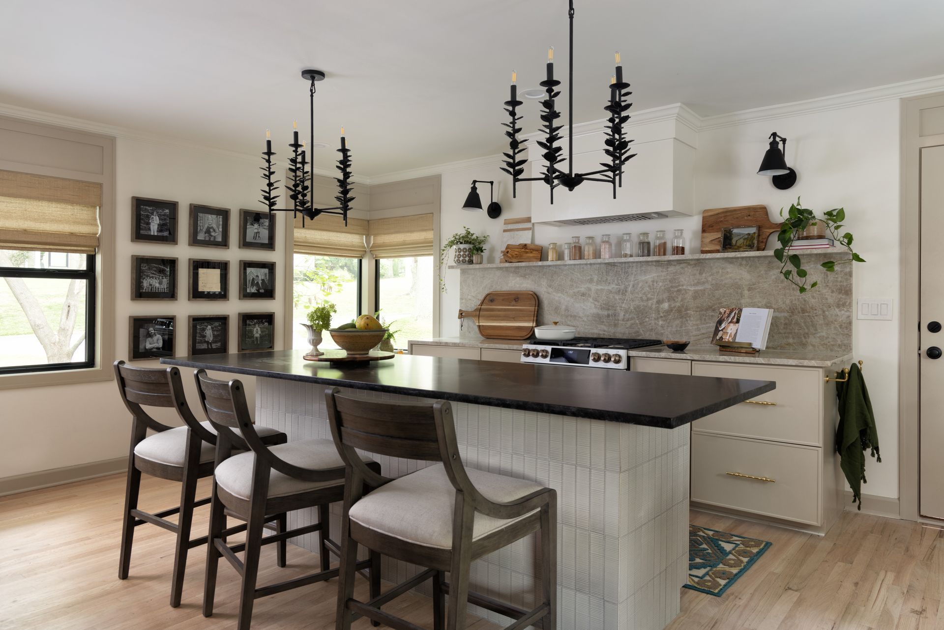 A kitchen with a large island , stools and a stove.