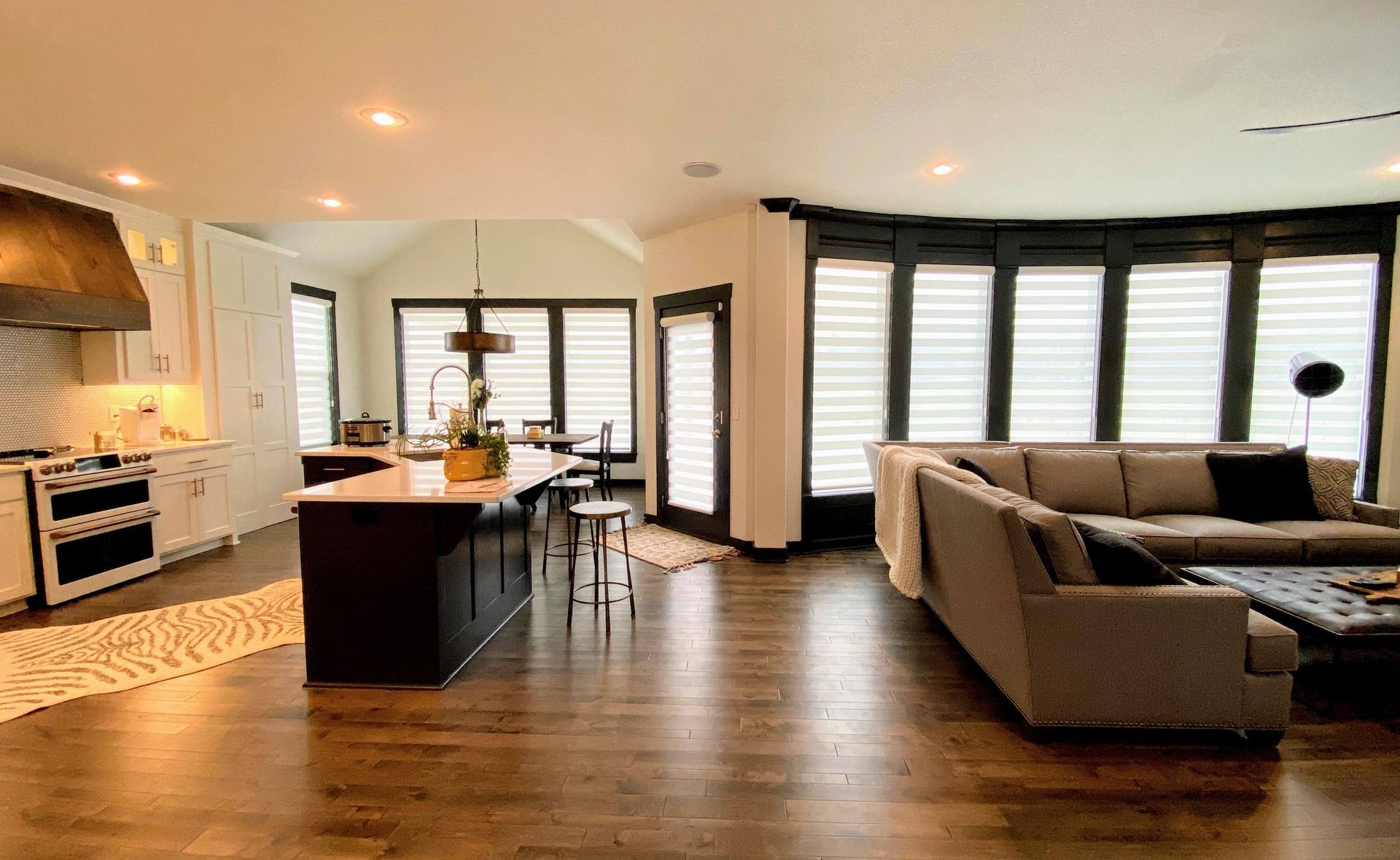A living room with a couch and a kitchen in the background.