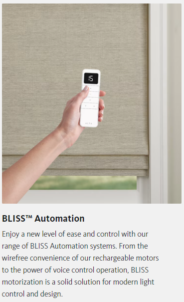 A person is holding a remote control over a window blind.