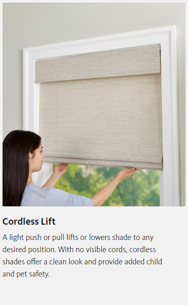 A woman is adjusting a cordless lift blind on a window.