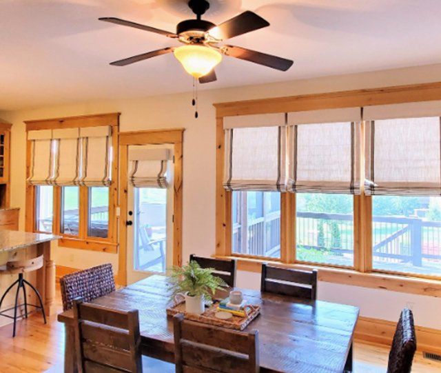 A dining room with a table and chairs and a ceiling fan