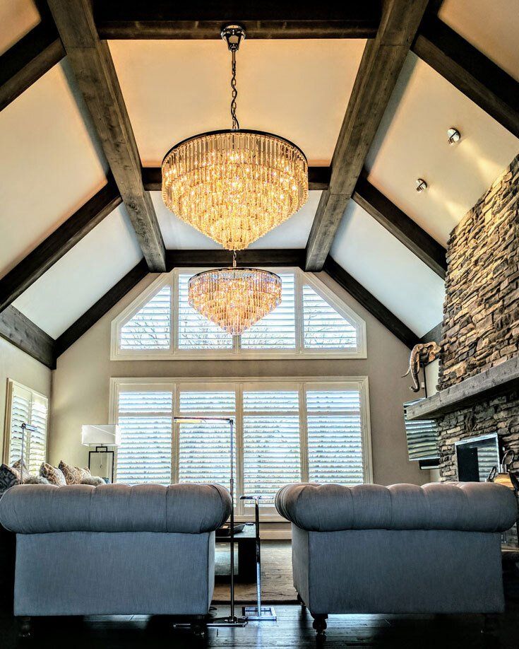 A living room with a large chandelier hanging from the ceiling