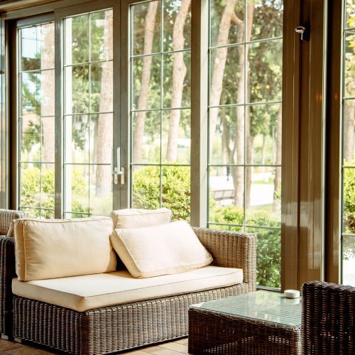 A living room with a wicker couch and a glass table