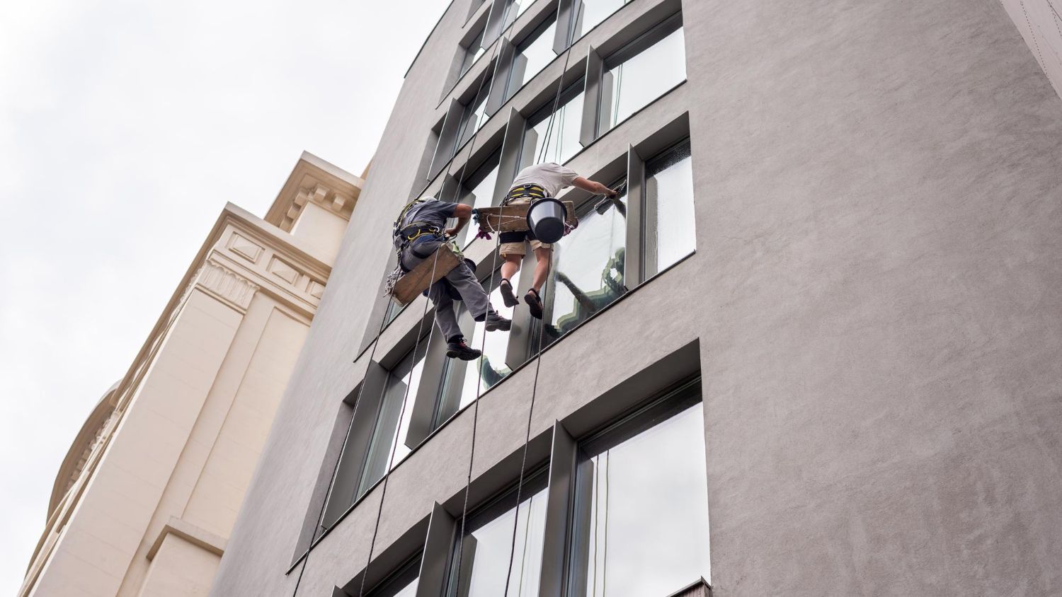Two workers washing windows
