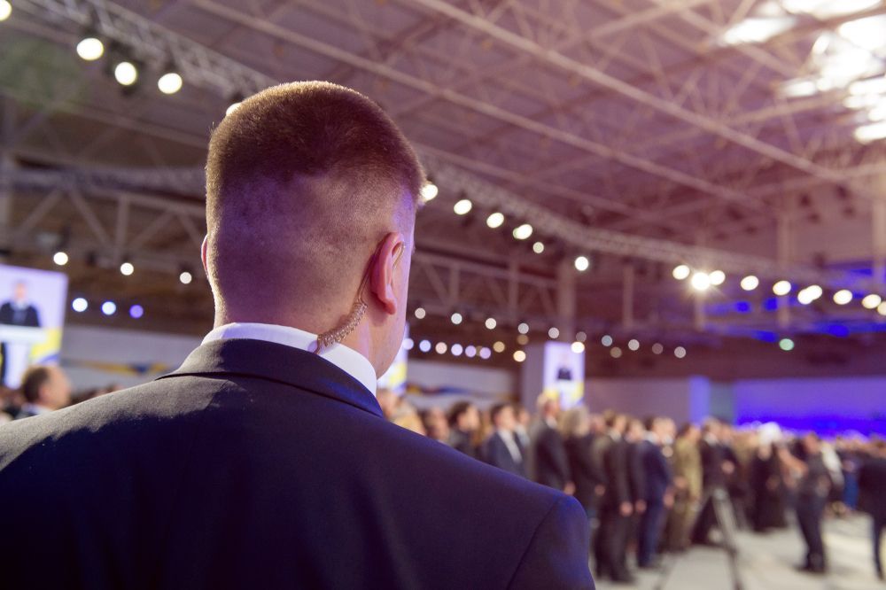 A Man in a Suit is Standing in Front of a Crowd of People — Asset Security Group In King Creek, NSW