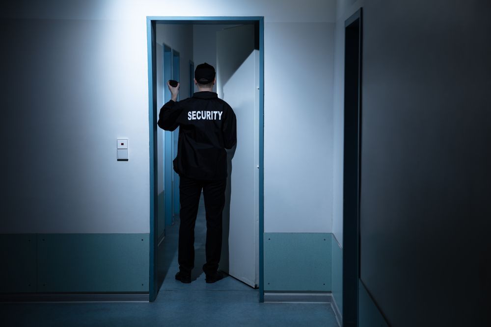 A Security Guard is Standing in the Doorway of a Building — Asset Security Group In Taree, NSW