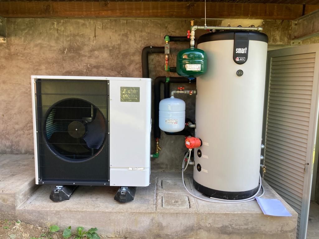 Un condizionatore d'aria bianco e nero e uno scaldabagno sono posizionati uno accanto all'altro.