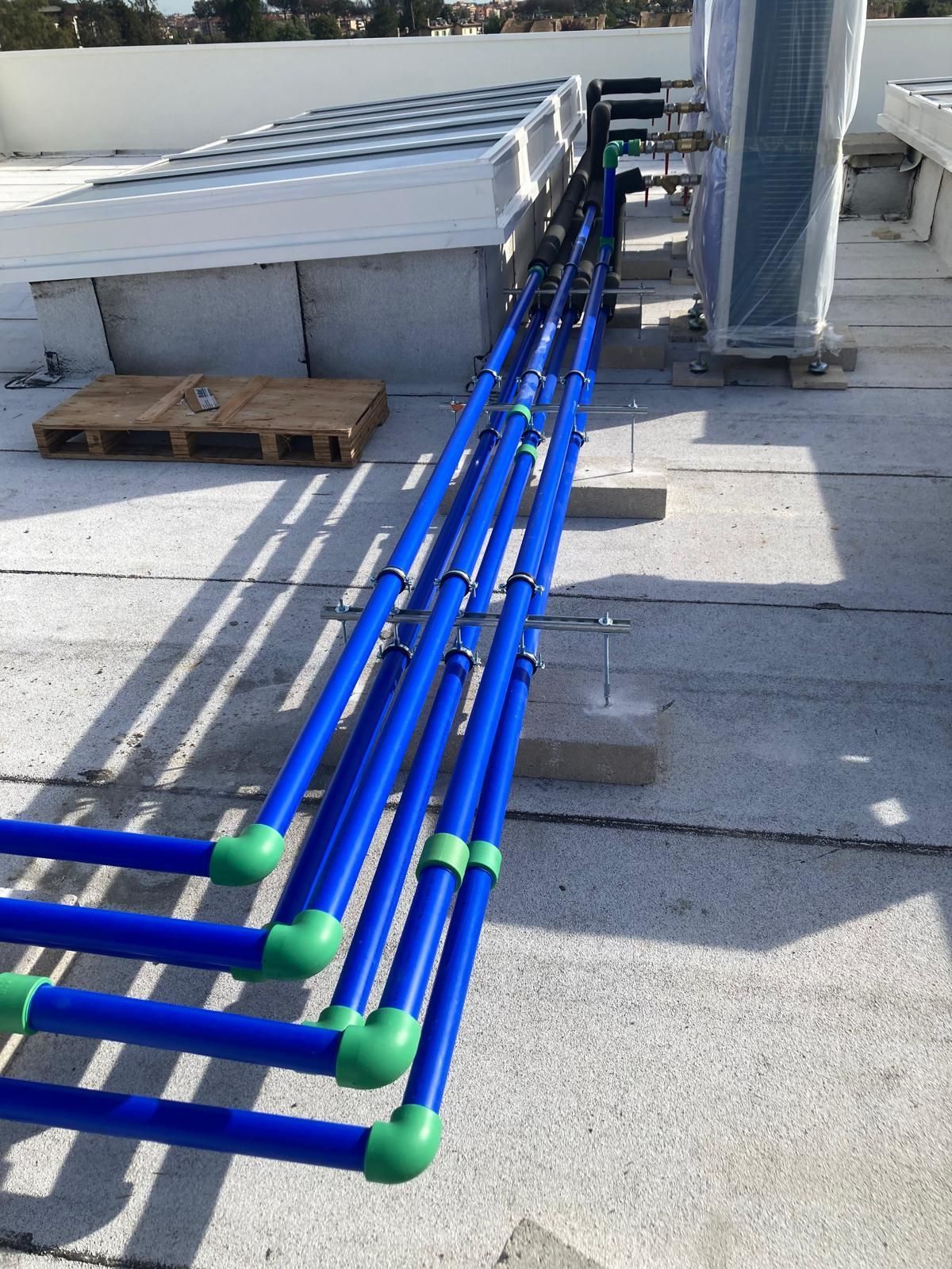 Una fila di tubi blu con tappi verdi su un tetto