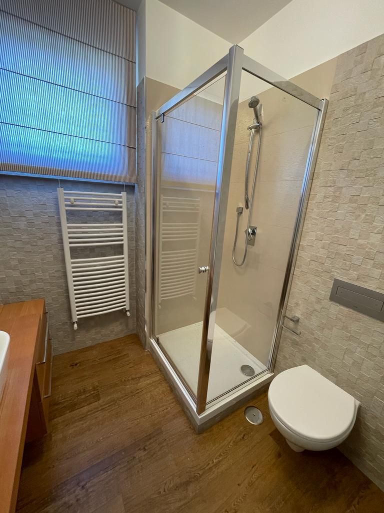 Un bagno con doccia, WC e portasciugamani.